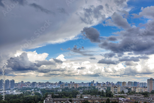 Thunderclouds fill the blue sky above the city. © Sergii