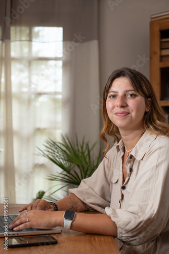 Canvastavla jolie jeune femme souriante qui travaille à la maison sur un ordinateur portable