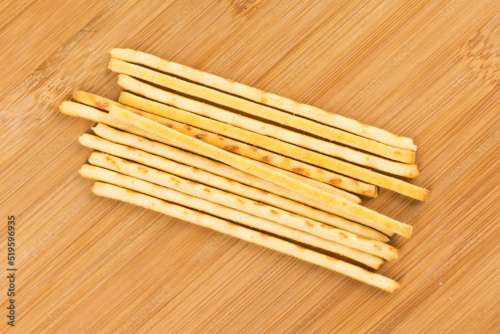 Corn snack sticks piled on a wood cutting board Corn snack sticks piled on a wood cutting board