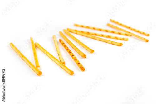 Fototapeta Naklejka Na Ścianę i Meble -  Scattered yellow corn snack sticks side view isolated over white