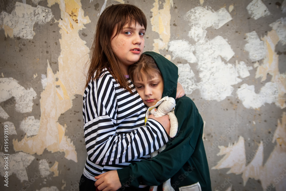 Terrified children near   old concrete wall