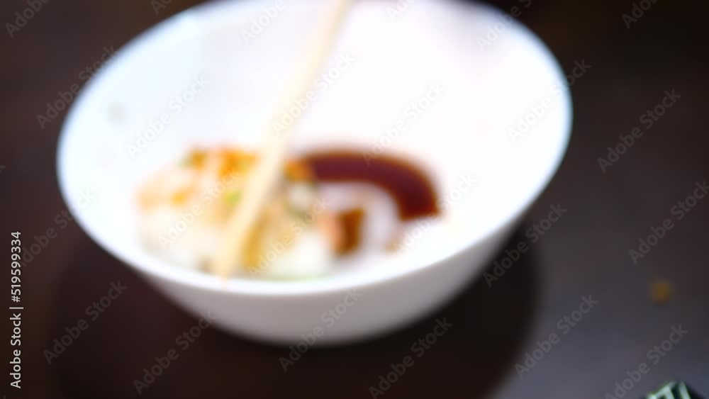 People using chopstick to pick up the sushi People using chopstick to pick up the sushi
