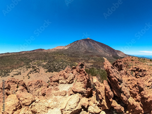 Scenic view on volcano Pico del Teide seen from Riscos de la Fortaleza, Mount El Teide National Park, Tenerife, Canary Islands, Spain, Europe. Hike via La Canada de los Guancheros dry desert plain photo