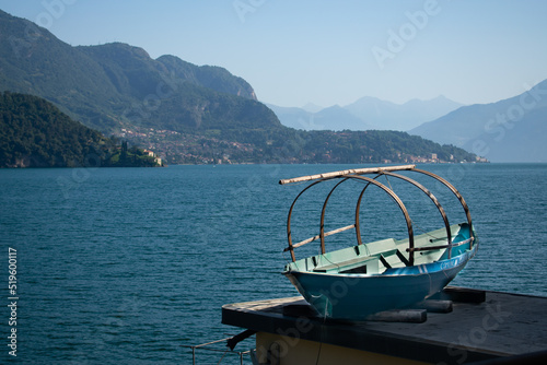 Traditional standing rowboat “Lucia” with lake como, Italy in the background