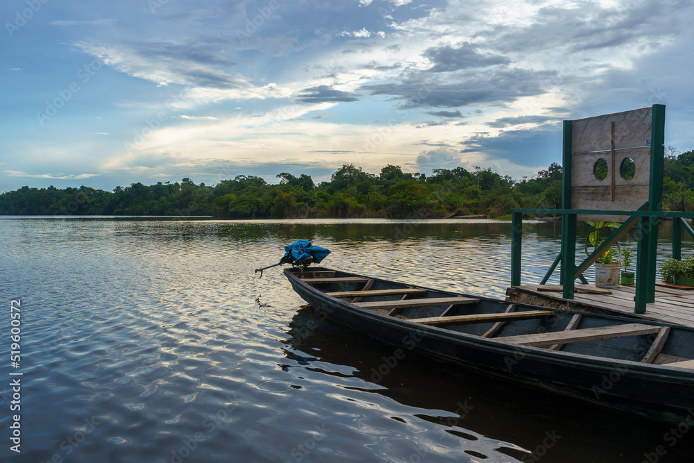 Beautiful sunset on the Amazona river with the wooden boat