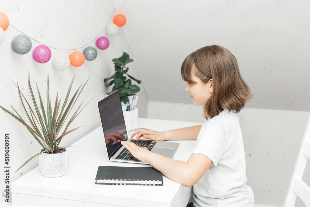 Distance learning at home. A schoolgirl girl does her homework on a laptop or watches a webinar online. Children and the Internet Distance learning at home. A schoolgirl girl does her homework on a laptop or watches a webinar online. Children and the Internet