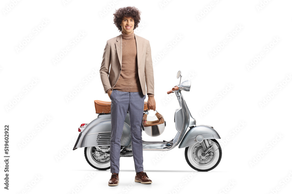 Full length portrait of a young man with curly hair holding a helmet and standing next to a scooter Full length portrait of a young man with curly hair holding a helmet and standing next to a scooter