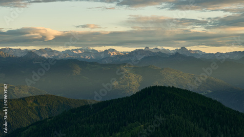 dreamy landscape with the moutians of the central alps in the distance and hazy sunset in the austrian alps near Dachstein