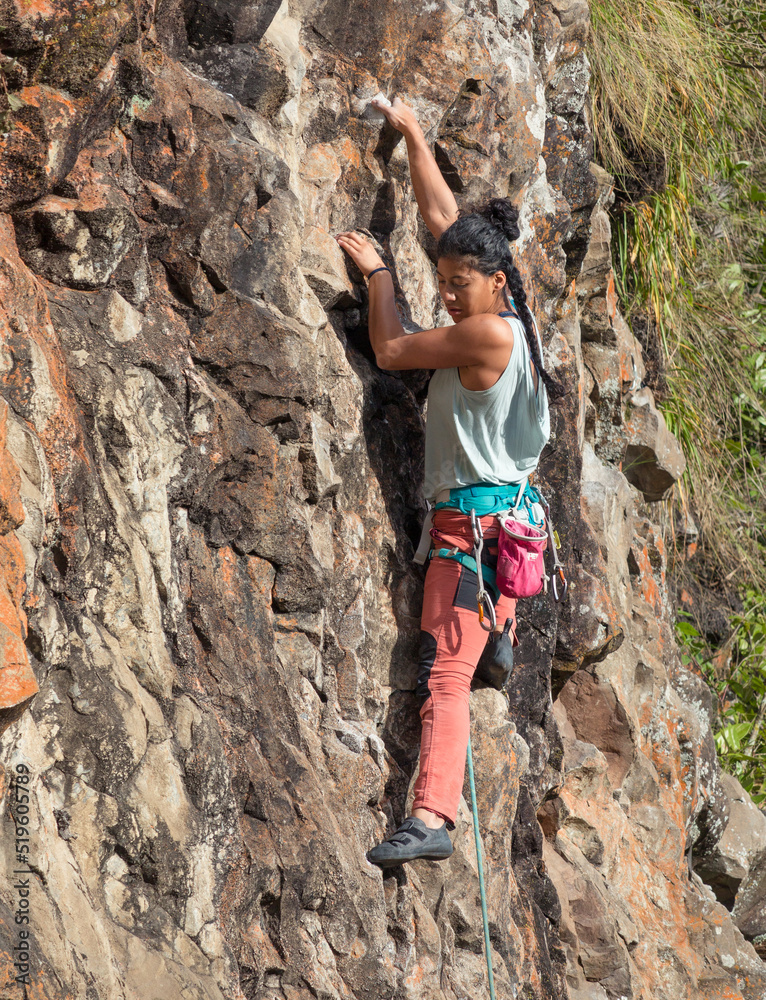 Strong female rock climber rock climbing