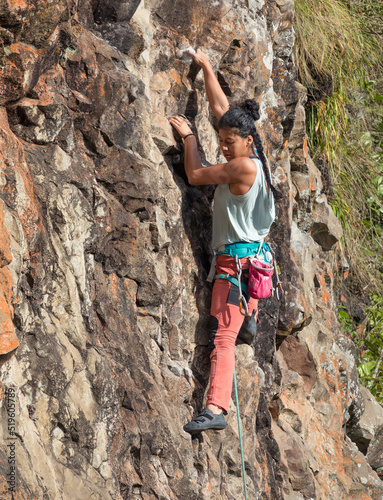 Strong female rock climber rock climbing