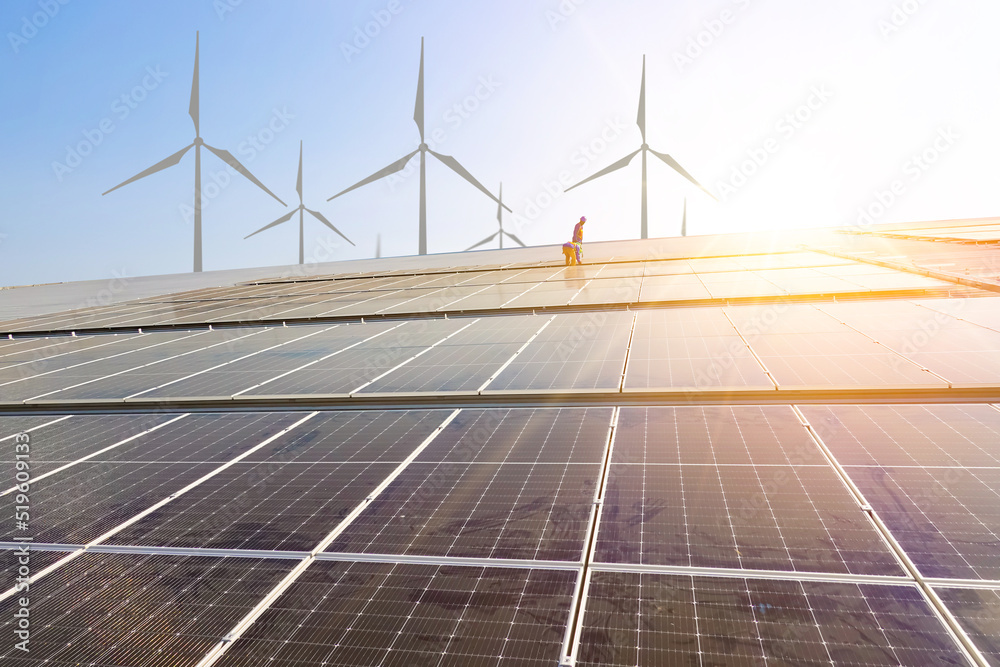Solar cell farm with blue sky and windmill background, renewable energy ...