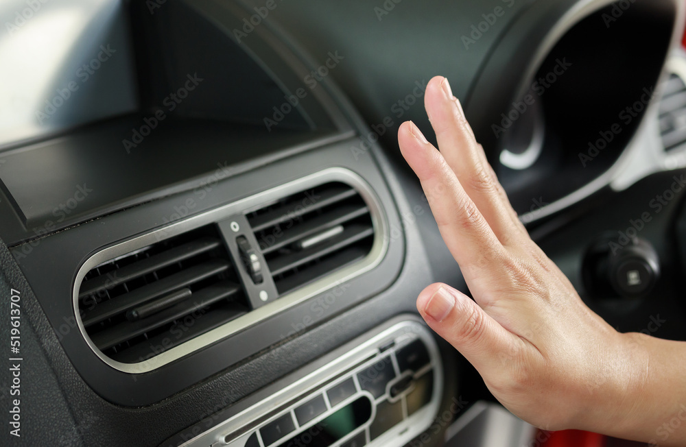 hand checking air conditioner system inside the car