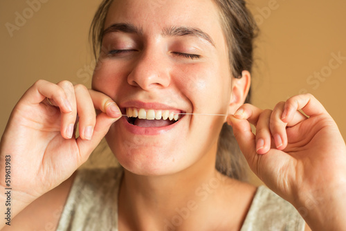 woman brushes her teeth with floss