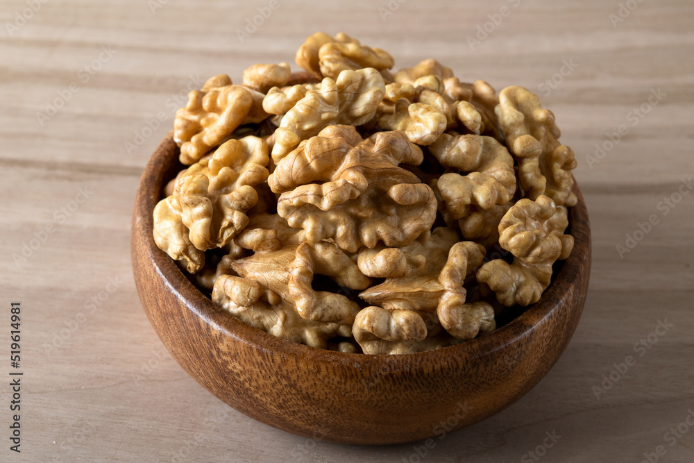 Bowl full of peeled walnuts on a wooden background Bowl full of peeled walnuts on a wooden background