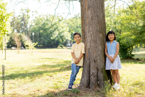 Fototapeta Naklejka Na Ścianę i Meble -  Asian kids posing by the tree in the park