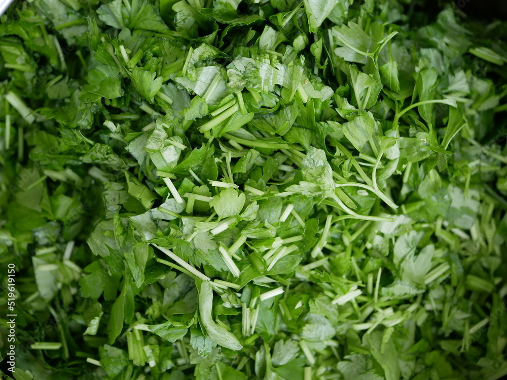 Finely chopped parsley on a plate. Ingredients for salad preparation. Preparation of vegetarian vitamin-containing food. Finely chopped parsley on a plate. Ingredients for salad preparation. Preparation of vegetarian vitamin-containing food.
