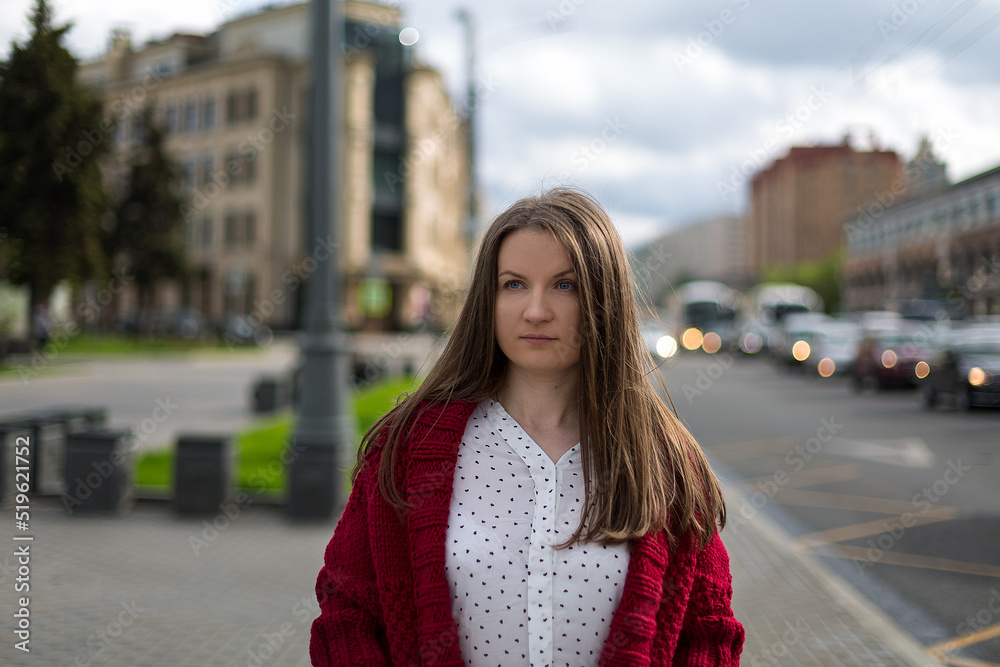 Street portrait of a young woman dressed in a burgundy long cardigan, cute autumn outfit.