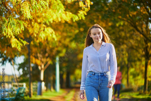 Beautiful young woman enjoying bright autumn day in Paris, France