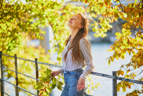 Beautiful young woman enjoying bright autumn day in Paris, France