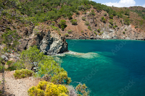 Picturesque seascape. View of bay of Mediterranean Sea with turquoise water and rocky red mountains from top of hill on sunny spring day. Calm. Hike along Lycian Way, Antalya, Kemer, Turkey. photo