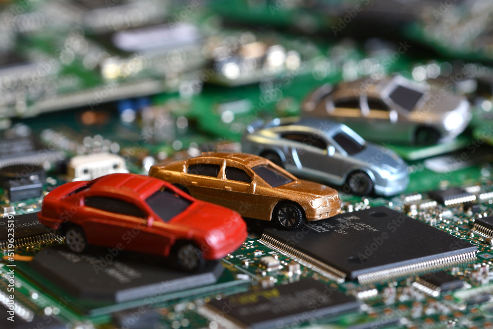 Toy cars on electronic board and microchip. Conceptual image for semiconductor shortage