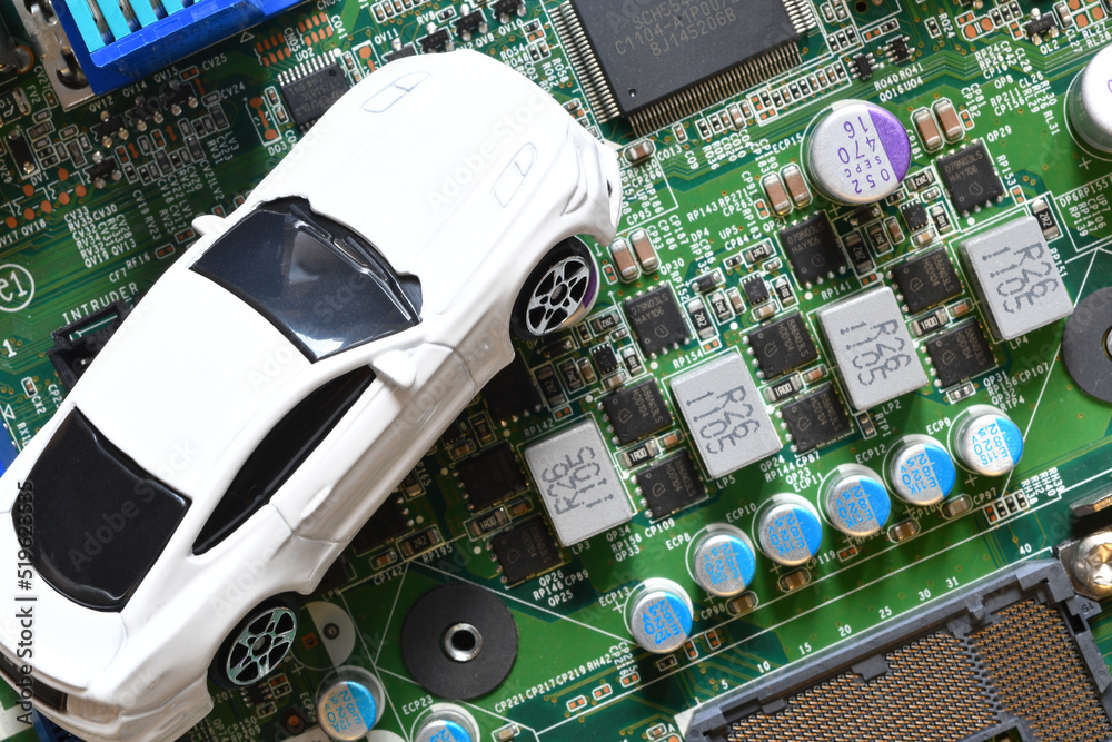 Toy cars on electronic board and microchip. Conceptual image for semiconductor shortage