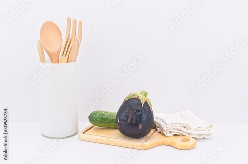 ortaggi da agricoltura biologica, utensili da cucina con tagliere in legno e canovaccio bianco su tavolo bianco - concetto di sana alimentazione
 photo