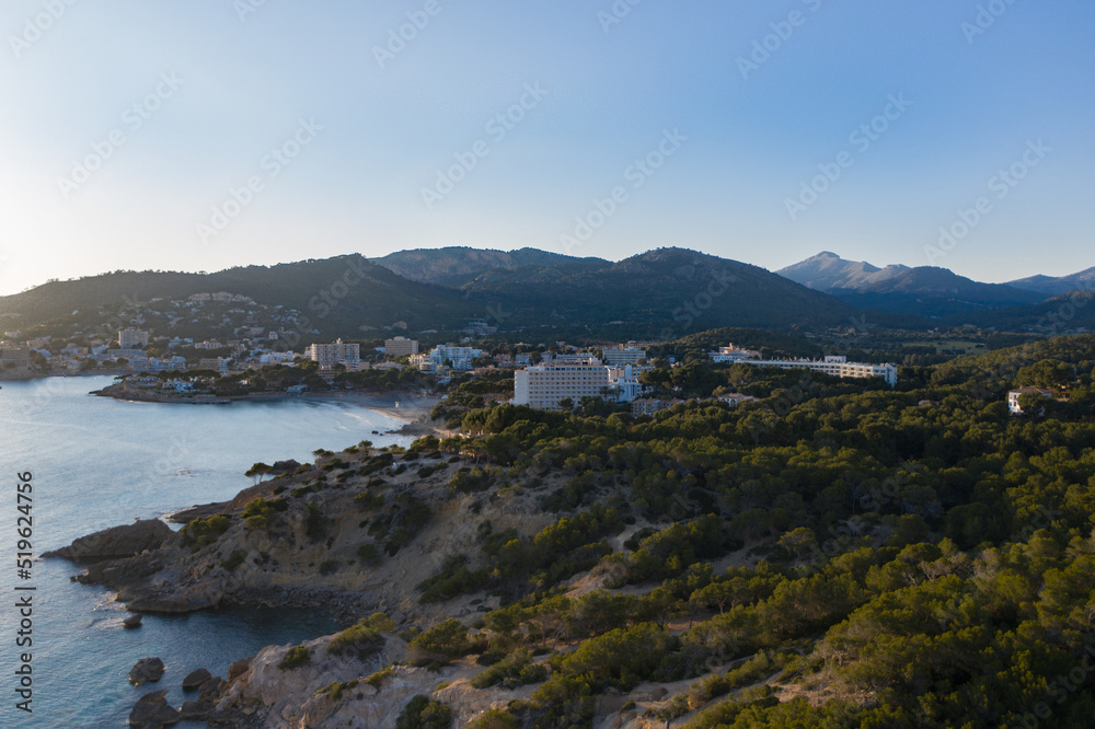Aerial view of Peguera at twilight from sea side with hotels and beaches. Mountains in background. Mallorca, Balearic Islands, Spain