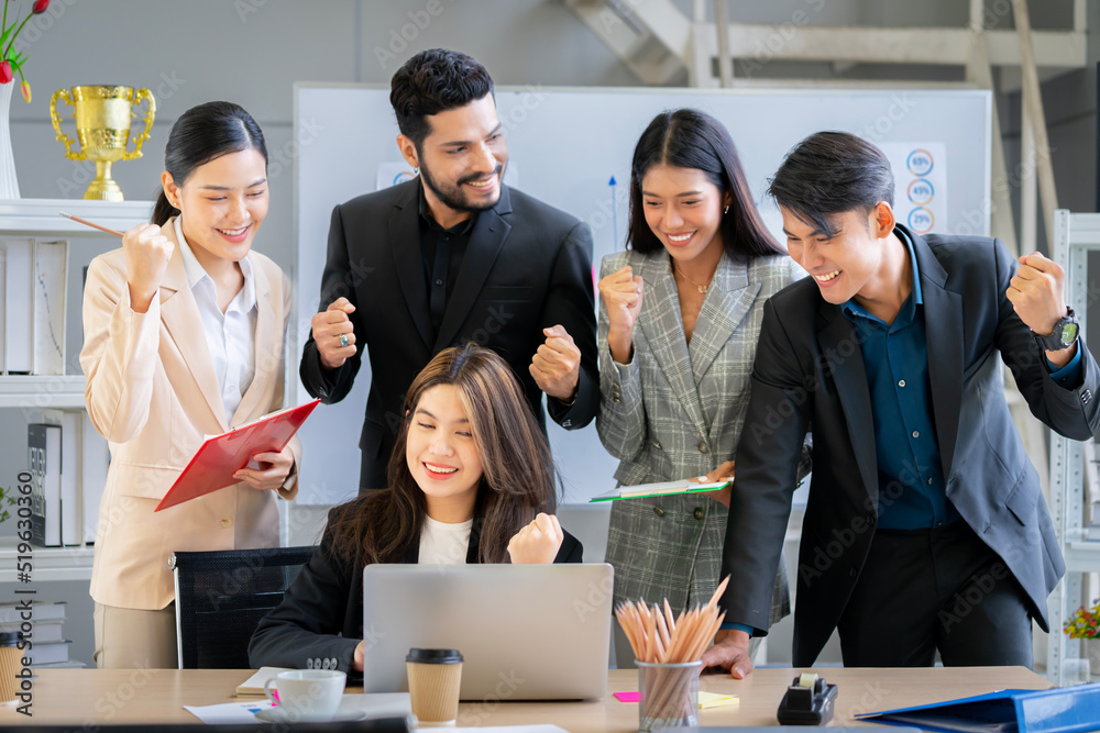 A group of young businessmen in suits, Asians, are determined and excited about their work. and encourage the team members by raising their hands happily A group of young businessmen in suits, Asians, are determined and excited about their work. and encourage the team members by raising their hands happily
