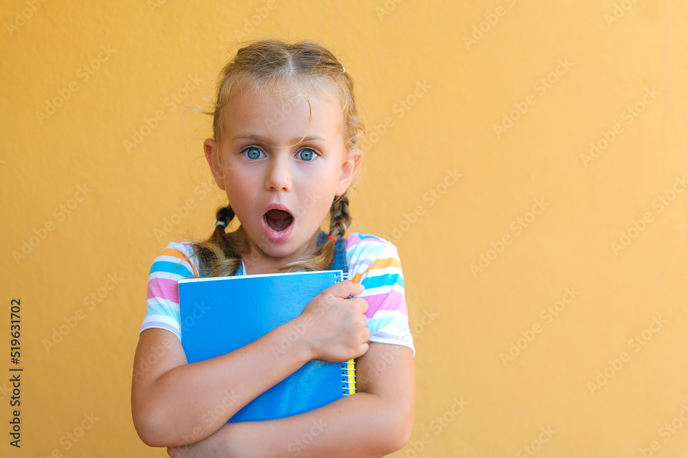 portrait of surprise cute little child school girl in striped T-shirt ...