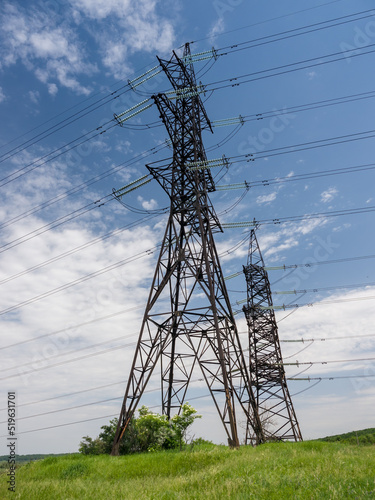 High voltage towers with wires, on a hill in the countryside, on a summer day. Close-up