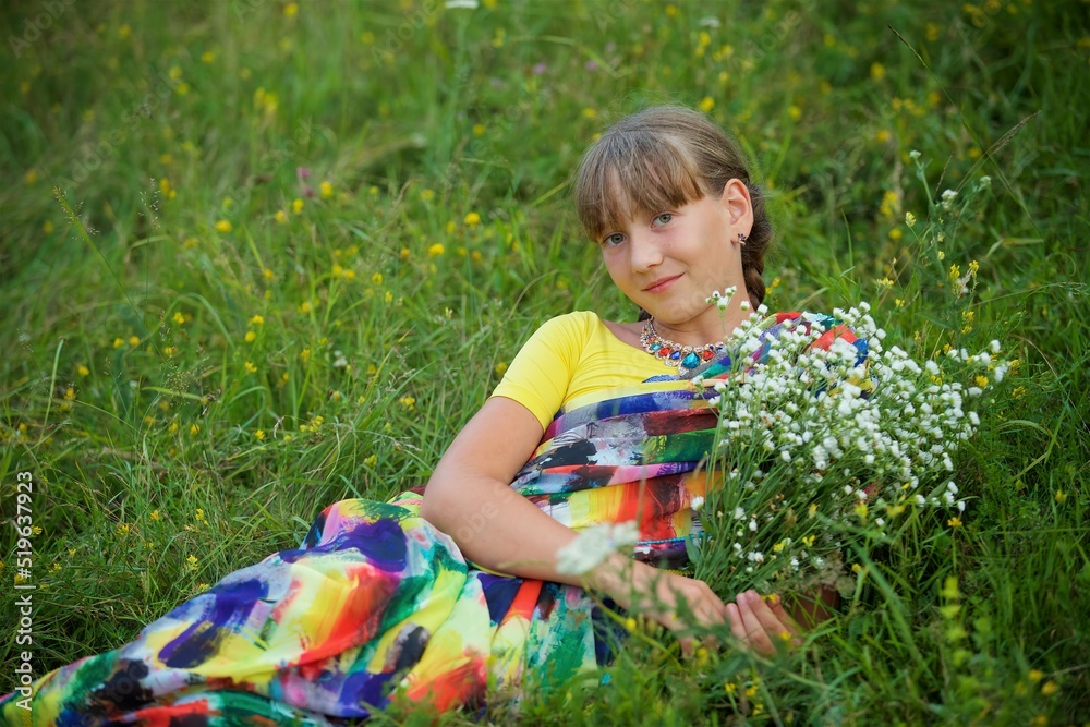 Girl European appearance in a traditional Indian Sari lying on the grass in a clearing Girl European appearance in a traditional Indian Sari lying on the grass in a clearing
