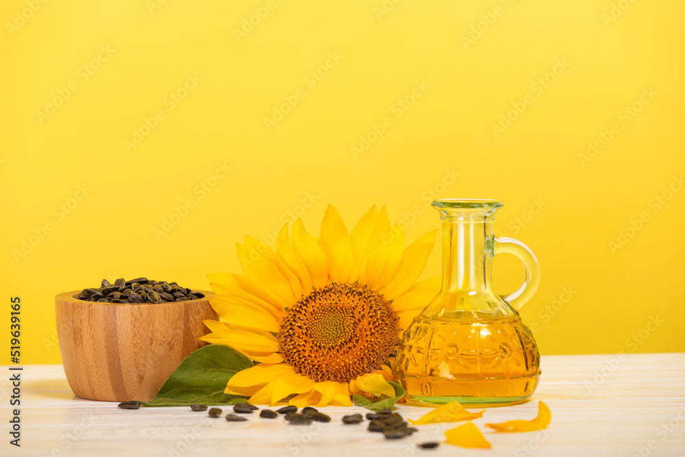 Organic sunflower oil in a small glass bottle with sunflower seeds and fresh flowers on the table. The concept of organic and environmentally friendly products. Healthy food and fats. Organic sunflower oil in a small glass bottle with sunflower seeds and fresh flowers on the table. The concept of organic and environmentally friendly products. Healthy food and fats.