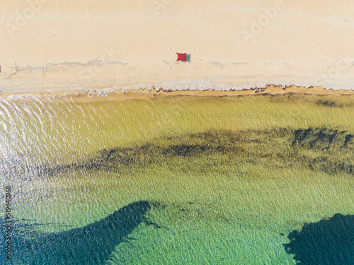 Aerial view of Paralia Issos beach in Corfu, Greece. Awning. Bathers strolling on the water's edge photo