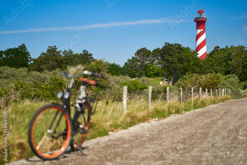 Lighthouse in Holland. Bike on the way. Cycling in Netherlands, Zeeland, West Schouwen. photo