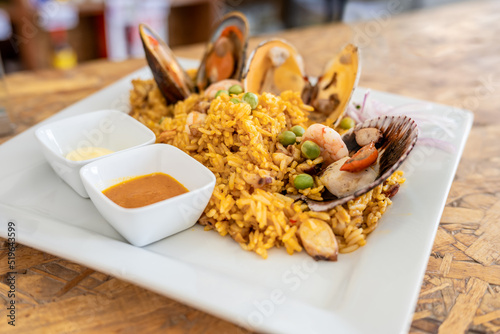 A view of a shrimp fried rice, in a restaurant or kitchen setting. wooden background