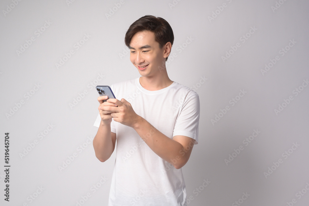 Young asian man using smartphone over white background, technology concept. .. Young asian man using smartphone over white background, technology concept. ..