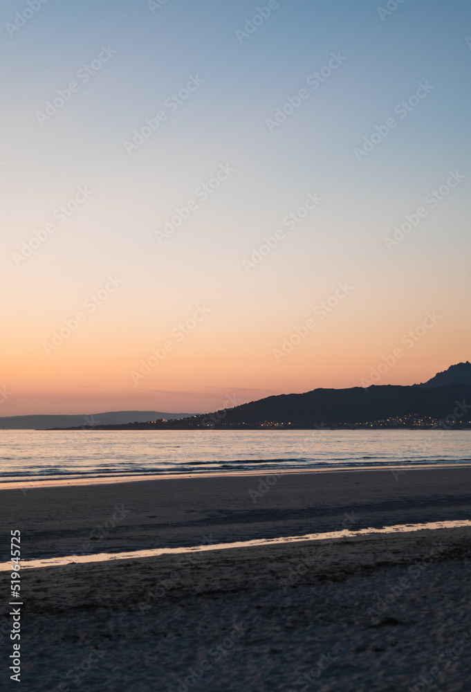 sunset on the beach with mountains