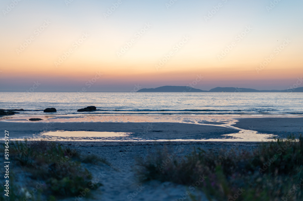 sunset on the beach with mountains