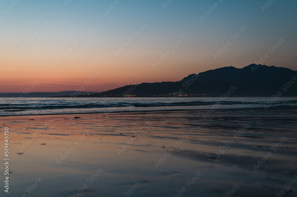 sunset on the beach with mountains