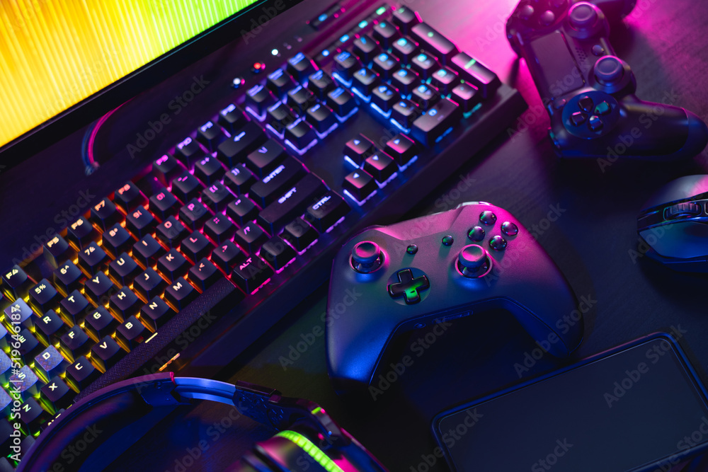 gamer work space concept, top view a gaming gear, mouse, keyboard, joystick,  and headset with rgb color on black table background. Photos | Adobe Stock