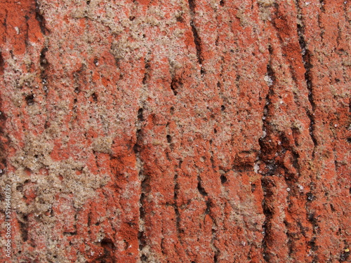 Close-up of a chipped red clay brick. Macro photo.