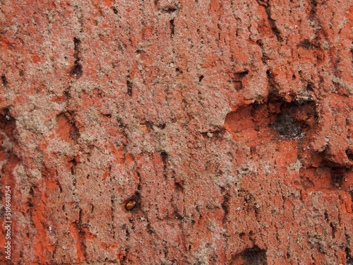 Close-up of a chipped red clay brick. Macro photo.