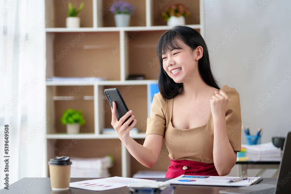 Beautiful young Asian businesswoman talking on the phone and excited about the success she has achieved. Beautiful young Asian businesswoman talking on the phone and excited about the success she has achieved.