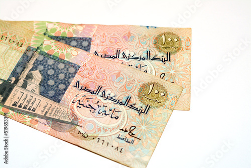 Obverse sides of an old 100 LE EGP one hundred Egyptian cash money banknote features Al-Sayida Zainab mosque in Cairo at centre, selective focus of withdrawn Egyptian Pound banknotes isolated on white photo
