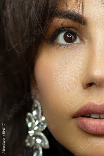 Half a beauty portrait with beautiful fashionable evening make-up, red liner on eyes and extremely long eyelashes. Pink lipstick on the lips. Cosmetology and spa facial skin care