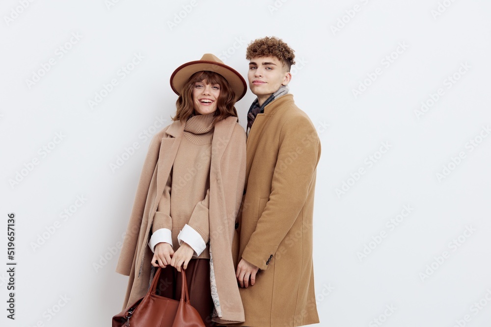 a happy couple a man and a woman stand in stylish autumn clothes on a white background close to each other and smile happily a happy couple a man and a woman stand in stylish autumn clothes on a white background close to each other and smile happily