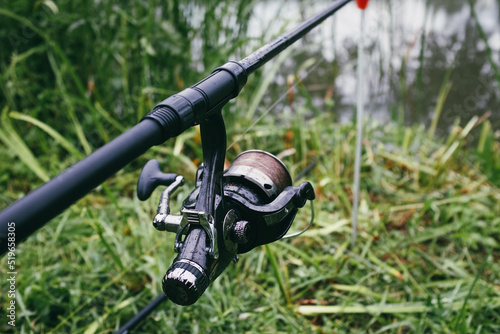 closeup of a fishing session with a angle on a river waiting in the grass for a fish to bite