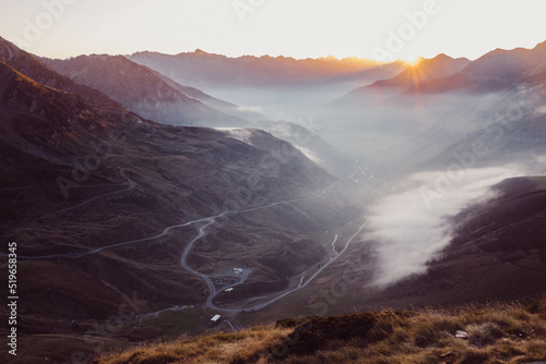 Road uphill to the mountain Col du tourmalet in the pyrenees in south france in the sunset. photo