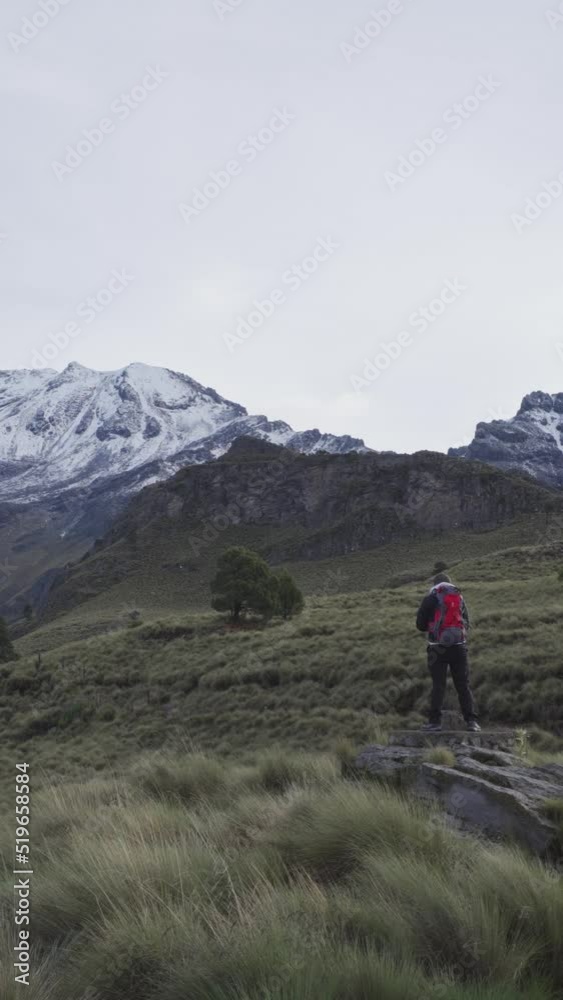 A hiker stands in front of the iztaccihuatl volcano A hiker stands in front of the iztaccihuatl volcano